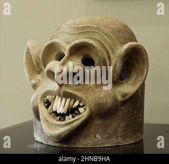 Masque d'argile Asaro Mudman des Highlands de l'est de Papouasie-Nouvelle-Guinée, avec un visage souriant grotesque et des oreilles exagérées, utilisé comme décor d'art tribal unique Banque D'Images
