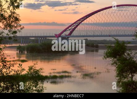 Pont Bugrinskij à l'aube, traversant la rivière OB. Haut pont de chemin de câbles voûté à travers la rivière large, l'aube rose douce, les arbres dans la wate Banque D'Images