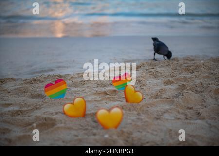 crow et lgbt et les coeurs jaunes dans le sable sont debout Banque D'Images