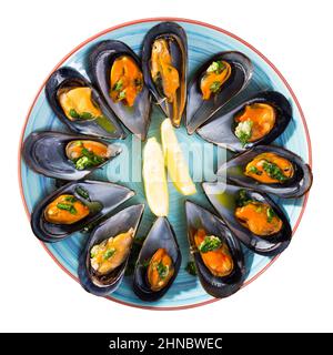 Vue de dessus des moules cuites à la vapeur avec du citron sur un plat bleu Banque D'Images