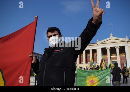 Athènes, Grèce. 15th févr. 2022. Un activiste kurde signe en marchant au centre de la capitale grecque et porte un drapeau kurde. Des dizaines d'activistes kurdes ont organisé une marche de protestation de 42 kilomètres entre le village historique de Marathon à Attica et l'ambassade de Turquie à Athènes, en branlant des drapeaux et en criant des slogans tels que ''Freedom for Ocalan''. Le 15 février 1999 : la Turquie, avec l'aide des États-Unis, a pris le dirigeant révolutionnaire kurde, Abdullah Ã-calan, en captivité au Kenya. Ã-calan était en route de l'ambassade grecque à l'aéroport et est resté emprisonné depuis. (Image crédit : © Dimitr Banque D'Images