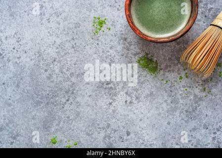 Thé vert Matcha dans un bol fait à la main avec un fouet en bambou. Banque D'Images