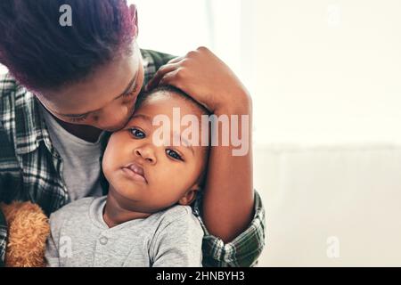 HES grandit si vite. Prise de vue d'une mère qui berce son petit garçon. Banque D'Images