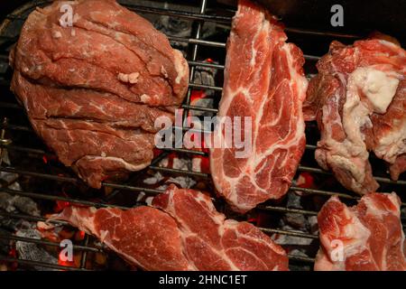 Barbecue de porc en fin de soirée avec des poutres de charbon de bois. Côtelettes de bonne couleur et savoureuses. Concept gastronomique Banque D'Images