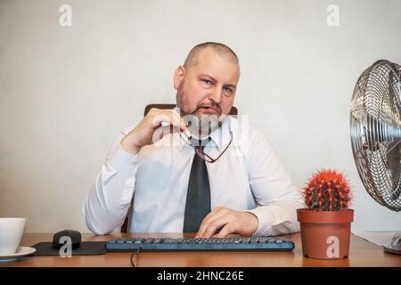 L'homme décrit comiquement le travail d'un homme d'affaires. Il montre son mécontentement sur son visage et sa posture. Banque D'Images