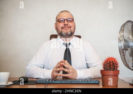 L'homme décrit comiquement le travail d'un homme d'affaires. Il montre le contentement et la joie sur son visage et sa posture. Banque D'Images