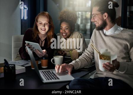 Il faut une équipe pour réussir. Photo d'un groupe de jeunes designers travaillant tard au bureau. Banque D'Images