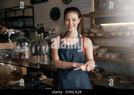 J'ai hâte d'être à votre service. Photo d'une jeune femme travaillant dans un café. Banque D'Images