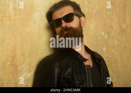 Portrait de l'homme beau. Hipster barbu sur fond de mur beige. Banque D'Images