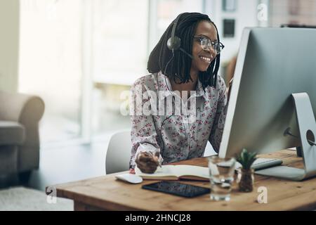 Appelez l'expert. Elle sait de quoi elle parle. Photo d'une jeune femme utilisant un casque et un ordinateur dans un bureau moderne. Banque D'Images