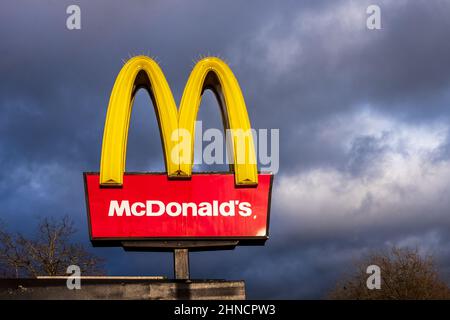 Un McDonalds signe contre un ciel orageux. L'enseigne du restaurant McDonald's britannique est illuminée par des nuages sombres. McDonalds Fast Food Restaurant Milton Keynes Royaume-Uni. Banque D'Images