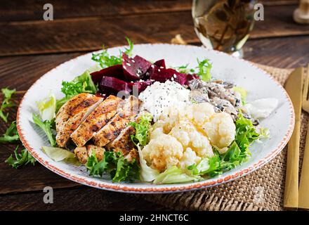 Déjeuner sain. Salade de betteraves bouillies avec légumes verts, compote de champignons, filet de poulet grillé et chou-fleur cuit au four. Dîner. Banque D'Images