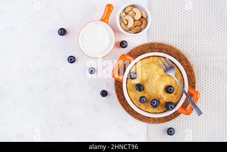 Cocotte de fromage cottage sur un plat de cuisson sur fond clair. Petit déjeuner sain. Vue de dessus Banque D'Images