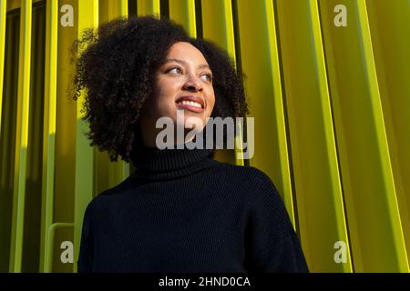 Femme médecin spécialiste en uniforme de protection, gants en latex et masque facial effectuant un test de bouche avec un coton-tige sur la femme afro-américaine i Banque D'Images