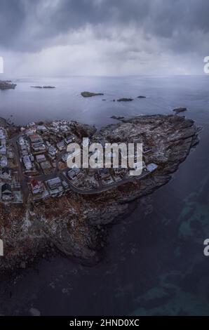 De dessus vue aérienne de l'eau calme de l'île de lavage de mer avec un village sous ciel nuageux à la plage de Vik à Lofoten, Norvège Banque D'Images