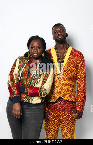Homme et femme heureux en se tenant sur fond blanc en studio. Ils regardent la caméra avec une expression sérieuse. Banque D'Images