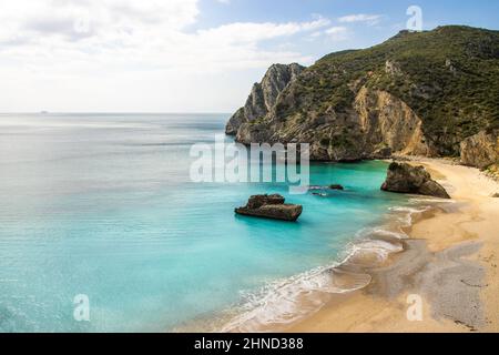 Plage secrète à Sesimbra avec de hautes falaises et de l'eau bleu ciel - Praia do Ribeiro do Cavalo Banque D'Images