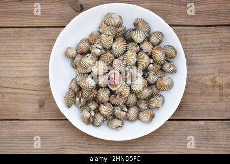 Des cottes sur fond de bois blanc, du sang frais de coquillages crus cotle fruits de mer gastronomiques de l'océan dans le restaurant Banque D'Images