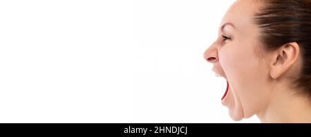 une femme hurle émotionnellement avec sa bouche largement ouverte, image de profil sur un fond blanc Banque D'Images