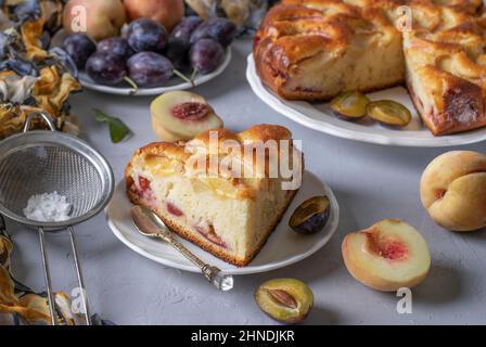 Tarte maison avec prunes et pêches, arrosée de sucre en poudre Banque D'Images