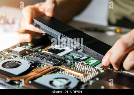 le technicien change et insère une nouvelle batterie d'ordinateur portable. service de réparation d'ordinateur Banque D'Images