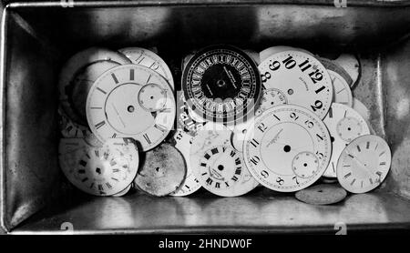 Pile de vieux visages de montre de poche en porcelaine dans une boîte en étain au marché aux puces de Brooklyn. Plan conceptuel pour le passage du temps. Banque D'Images