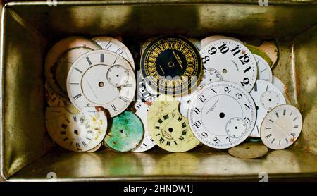 Pile de vieux visages de montre de poche en porcelaine dans une boîte en étain au marché aux puces de Brooklyn. Plan conceptuel pour le passage du temps. Banque D'Images