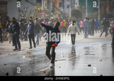 Katmandou, Népal. 16th févr. 2022. Des manifestants hurle des briques et des pierres à la police anti-émeute lors d'une manifestation à Katmandou. Différents partis politiques ailes de jeunes s'opposent à la police népalaise en dehors du Parlement fédéral pour protester contre le pacte du compte du Millénaire Népal (MCA-Népal) avec Millennium Challenge Corporation (MCC), une AIDE américaine à Katmandou. Crédit : SOPA Images Limited/Alamy Live News Banque D'Images