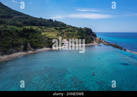 Vue avec la chapelle de bord de mer d'Agios Nikolaos près des villages de Skala et Paramonas dans la région de Meliteieis sur la rive ouest de Corfou, les îles Ioniennes, Grèce Banque D'Images