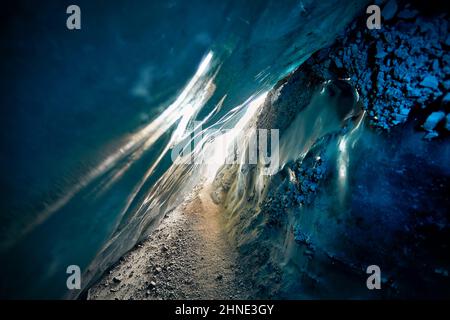 Paysage d'une incroyable grotte de glace glaciaire avec des lumières bleues à l'intérieur de la paroi de glace profonde dans le glacier de montagne d'hiver au Kazakhstan Banque D'Images
