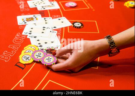 main tenant des jetons à la table du casino Banque D'Images