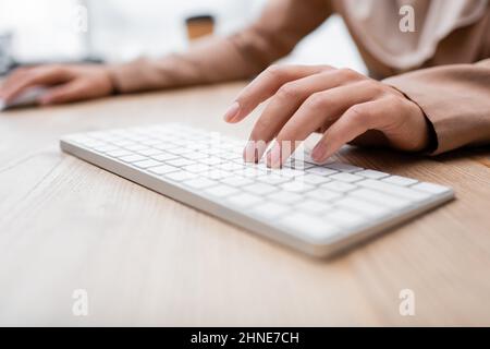 vue partielle de la femme tapant sur le clavier pendant son travail à la maison Banque D'Images