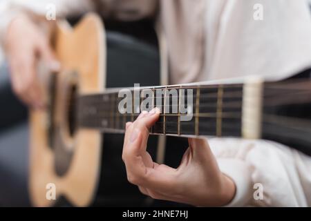 vue partielle d'une jeune femme jouant de la guitare acoustique Banque D'Images