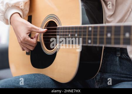 vue rapprochée d'une femme écourtée jouant de la guitare acoustique Banque D'Images