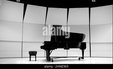 Piano noir et blanc avec banc d'essai sur l'état de concert pour la musique de performance théâtre musical Banque D'Images