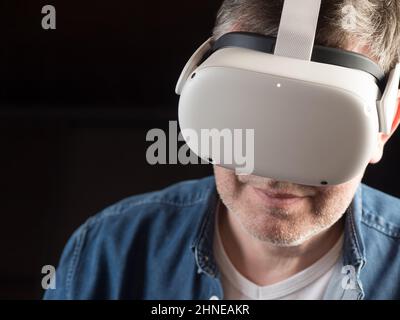 Homme habillé de façon décontractée portant un casque de réalité virtuelle Banque D'Images