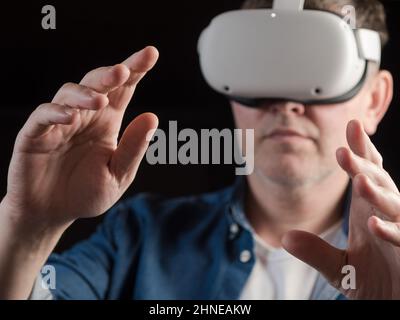 Homme habillé de façon décontractée portant un casque de réalité virtuelle Banque D'Images