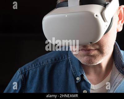 Homme habillé de façon décontractée portant un casque de réalité virtuelle Banque D'Images