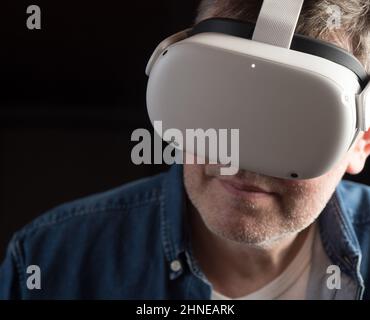 Homme habillé de façon décontractée portant un casque de réalité virtuelle Banque D'Images