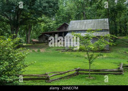 Ferme rustique et vacante, nichée dans les montagnes du nord de la Géorgie, intacte et bien préservée avec une grande véranda en bois, une clôture rugueuse et quelques dépendances Banque D'Images