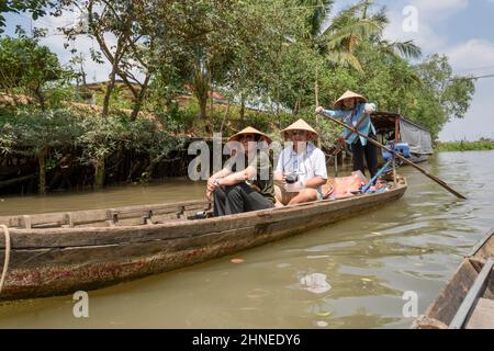 Femme vietnamienne avirant des touristes le long du Mékong dans un bateau traditionnel en bois (sampan), Delta du Mékong, province de Vinh long, sud du Vietnam, Sou Banque D'Images