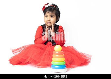 Fille indienne asiatique jouant avec des blocs de superposition avec des formes de tri isolées sur fond blanc. Amusement, activité, pré-école, éducation, maternelle, Banque D'Images