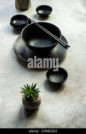 Décor asiatique minimaliste avec baguettes et une maison sur une table Banque D'Images