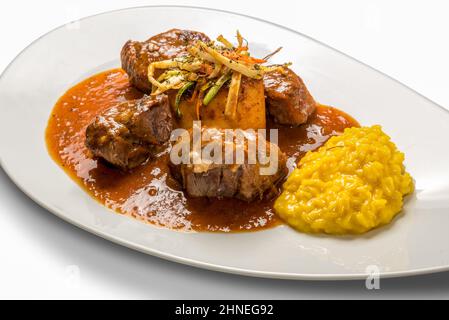 Ossobuco Milanese - viande de bœuf à trous d'os avec risotto au safran jaune italien en plaque blanche isolée sur le blanc Banque D'Images