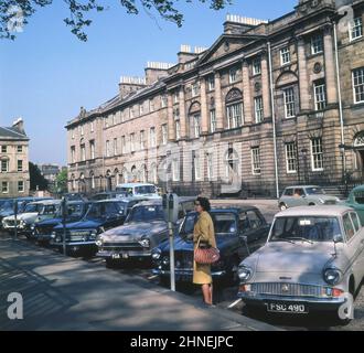 Années 1960, vue historique de Charlotte Square, Édimbourg, Écosse, Royaume-Uni. Voitures de l'époque garées - une Ford Anglia et une Cortina peuvent être vus et une dame debout regardant les parcomètres de la journée. Nommée d'après la reine Charlotte, épouse de George III, la place de la ville a été conçue par le célèbre architecte Robert Adam en 1791. Banque D'Images