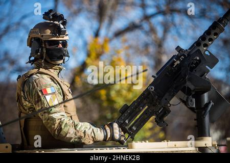 Bucarest, Roumanie - 1 décembre 2021 : un soldat tient une mitrailleuse sur le toit d'un porte-troupes blindé, lors d'un défilé militaire à Buchares Banque D'Images