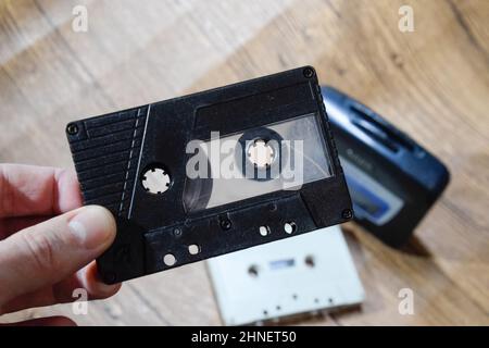 Cassette audio. Milieu de musique rétro, cassette compacte pour magnétophone, cassette audio dans les mains d'un homme. Audio rétro. Banque D'Images