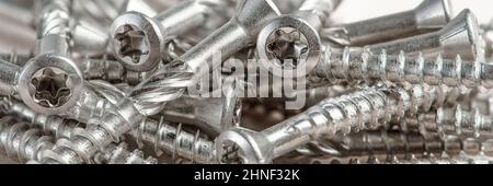 Gros plan des vis argentées universelles avec tête Torx. Vis autotaraudeuses pour bois, contreplaqué ou aggloméré. Les vis Torx se ferment. Banque D'Images