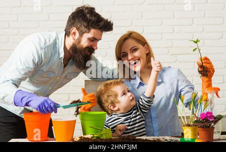 Bonne famille plantant des fleurs ensemble. Entretien des plantes. Jardinage découverte et enseignement. Banque D'Images