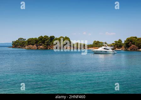 Photo panoramique de la mer turquoise avec un yacht blanc amarré dans la baie lors d'une journée d'été en Grèce Banque D'Images